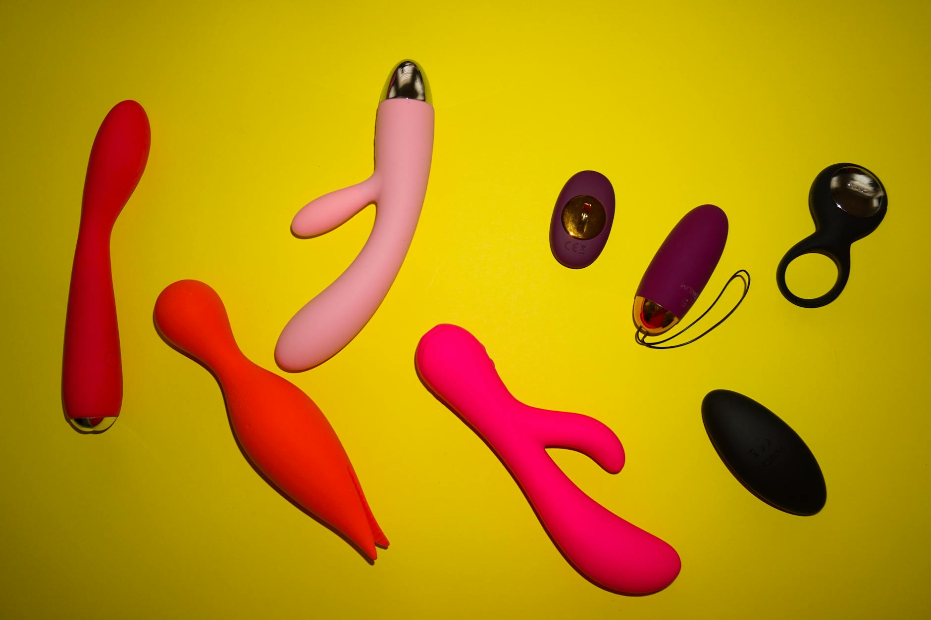 A hand holding a blue clitoral vibrator against a solid background, symbolizing self-care and personal exploration