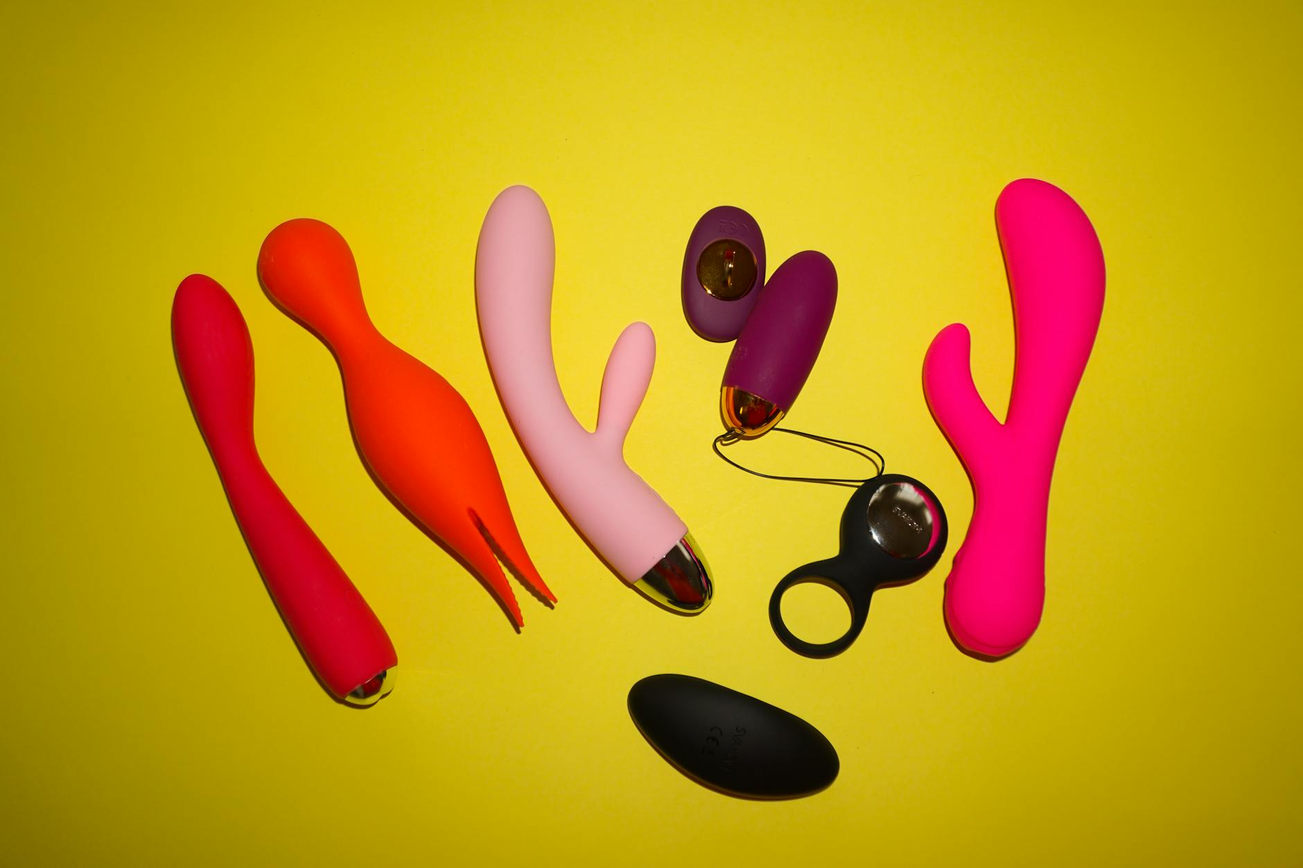 Woman holding vibrators in a moment of intentional self-discovery